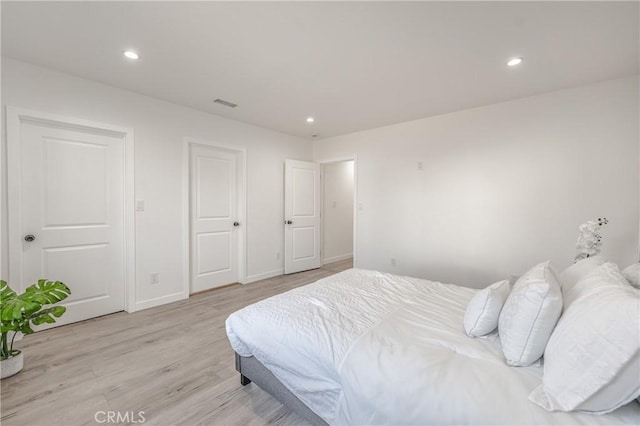 bedroom featuring recessed lighting, light wood-style floors, visible vents, and baseboards