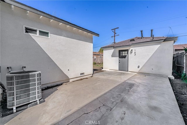 rear view of property featuring cooling unit, fence, a patio area, and stucco siding