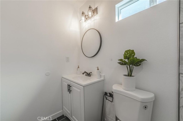 bathroom featuring vanity, toilet, and baseboards