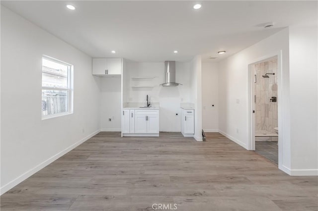 washroom featuring recessed lighting, light wood-type flooring, baseboards, and a sink