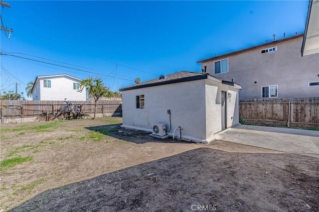 rear view of property with stucco siding, a fenced backyard, and ac unit