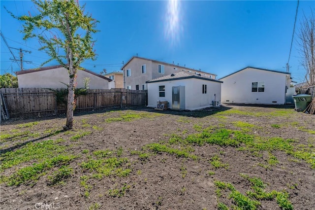 back of property featuring a fenced backyard and stucco siding