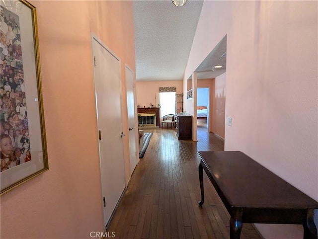 corridor with a textured ceiling and wood-type flooring