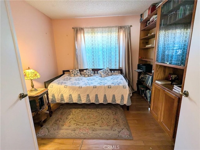 bedroom featuring a textured ceiling and wood finished floors