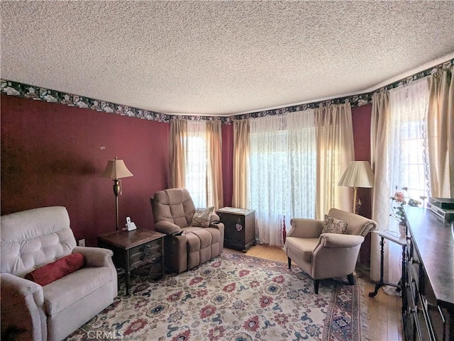 living area featuring plenty of natural light, wood finished floors, and a textured ceiling