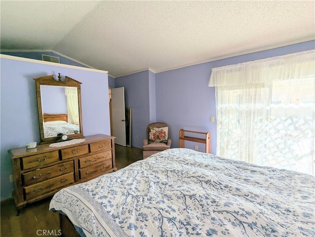 bedroom featuring visible vents, a textured ceiling, and lofted ceiling