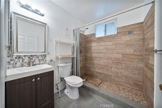 bathroom with tiled shower, backsplash, toilet, and vanity