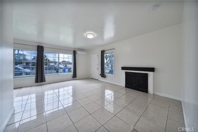 unfurnished living room featuring baseboards, light tile patterned flooring, a fireplace, and a wall mounted AC