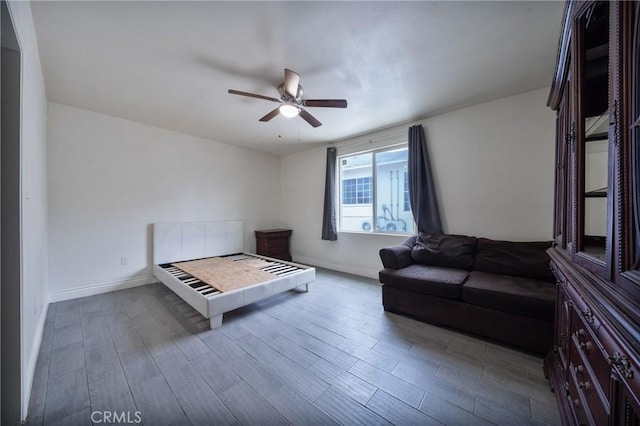 bedroom featuring a ceiling fan, wood finished floors, and baseboards