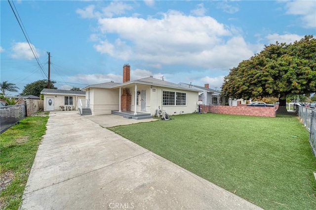 view of front of home with stucco siding, driveway, fence, a front yard, and a chimney