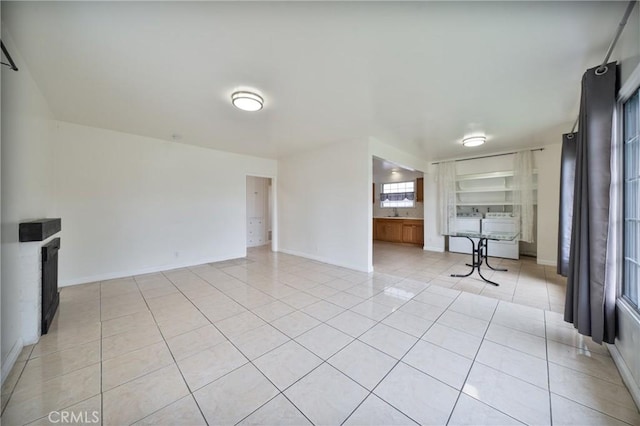 unfurnished living room featuring light tile patterned floors and baseboards