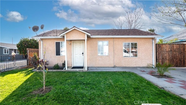 bungalow with stucco siding, a front yard, and fence