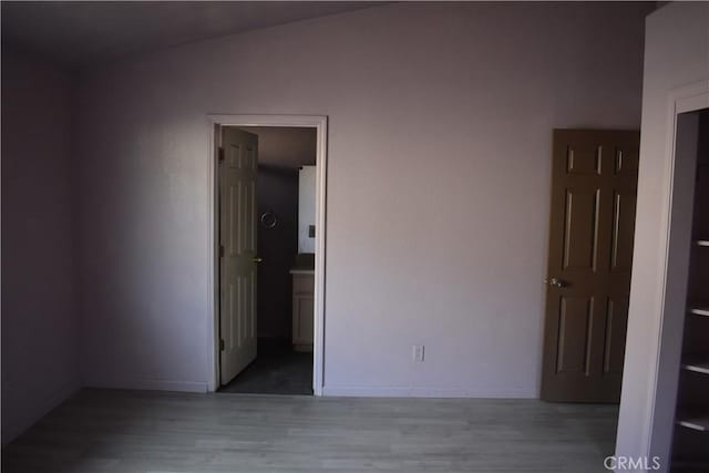 spare room with baseboards and wood finished floors