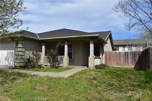 rear view of house featuring stucco siding, a garage, a lawn, and fence