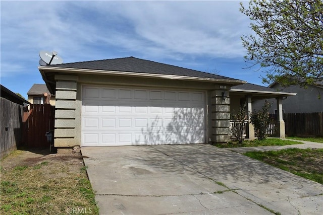 view of front of property featuring an attached garage, fence, and driveway