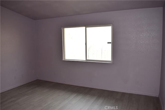 empty room with baseboards and wood finished floors