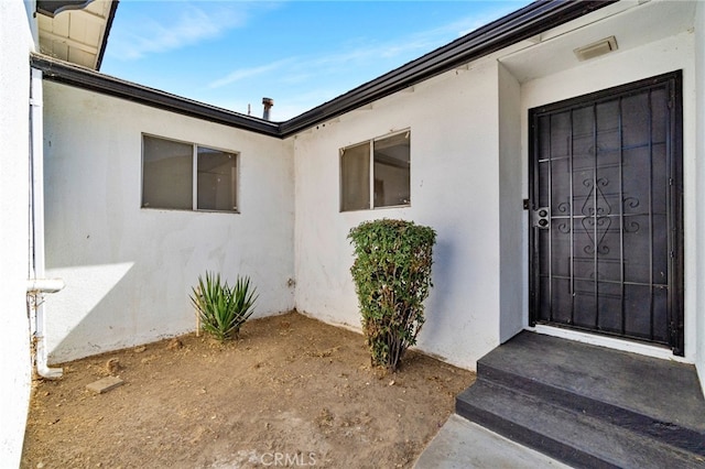 view of exterior entry featuring stucco siding