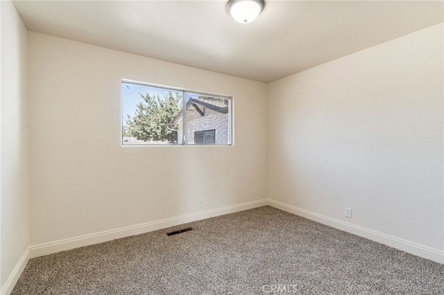 spare room with visible vents, baseboards, and carpet