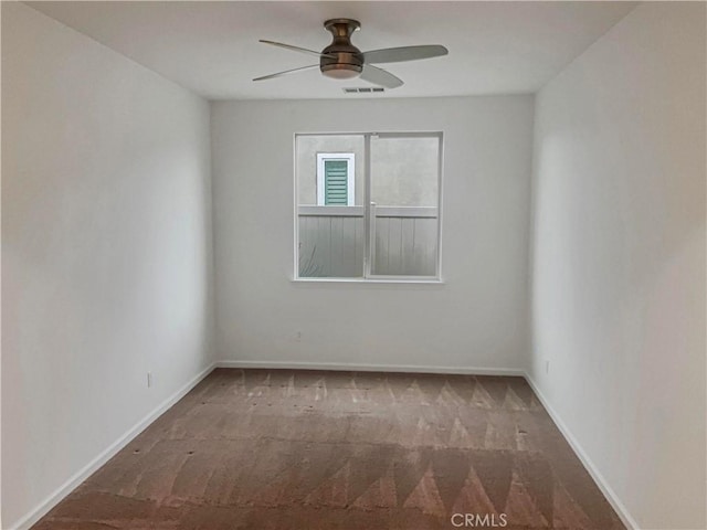 empty room with baseboards, carpet, visible vents, and ceiling fan