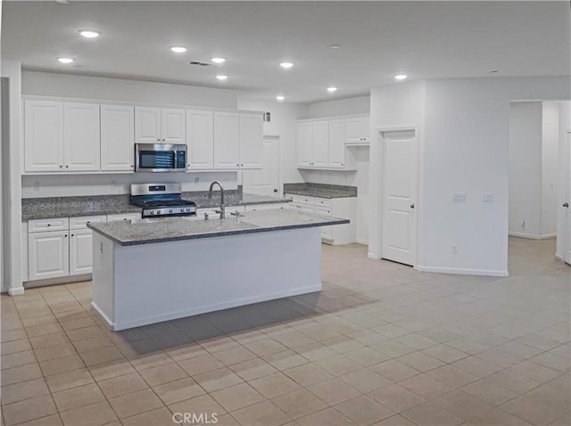 kitchen with recessed lighting, white cabinets, stainless steel appliances, and dark stone countertops