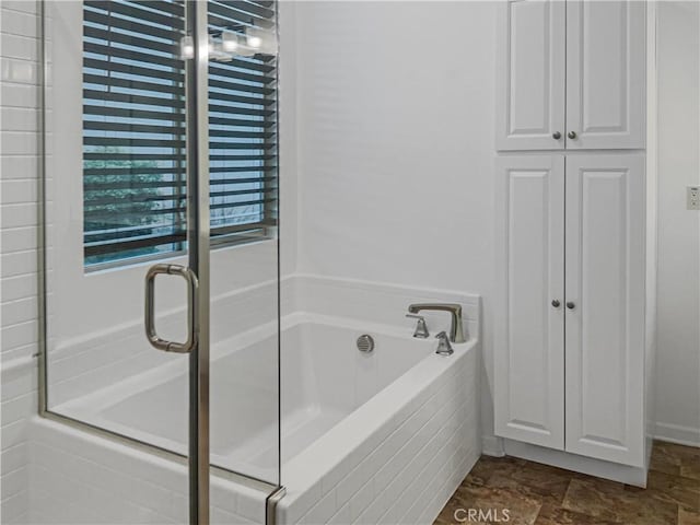 full bathroom with a shower stall and a garden tub