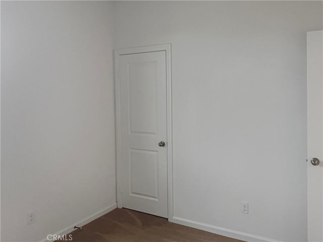 carpeted empty room featuring baseboards