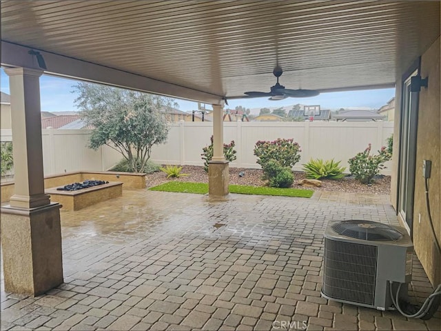 view of patio with a fenced backyard, an outdoor fire pit, central AC, and a ceiling fan