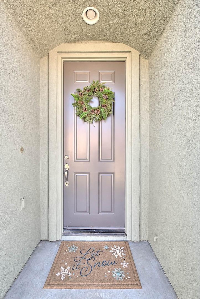 doorway to property featuring stucco siding