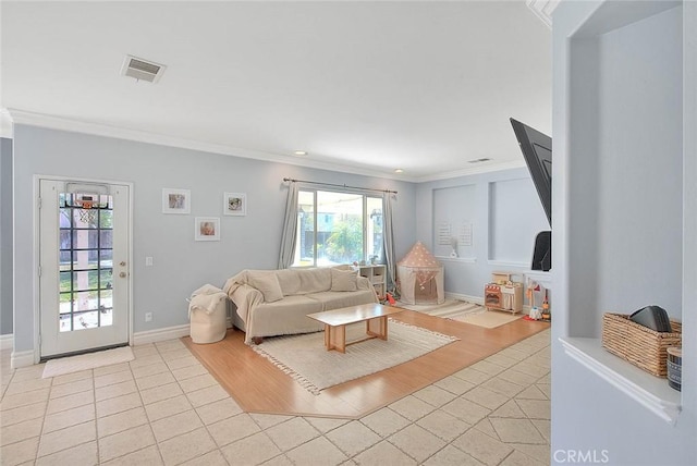 living area with light tile patterned flooring, visible vents, crown molding, and baseboards