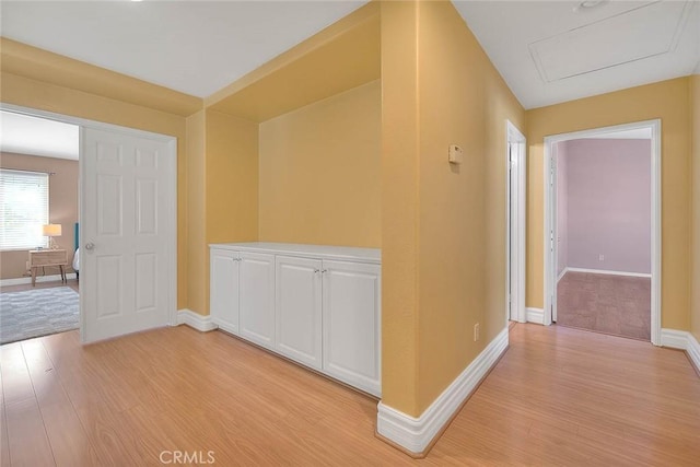 hallway featuring light wood-type flooring and baseboards