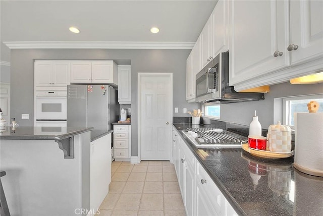 kitchen with white cabinetry, recessed lighting, appliances with stainless steel finishes, a breakfast bar area, and light tile patterned floors