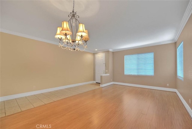 spare room with a chandelier, baseboards, light wood-style flooring, and crown molding