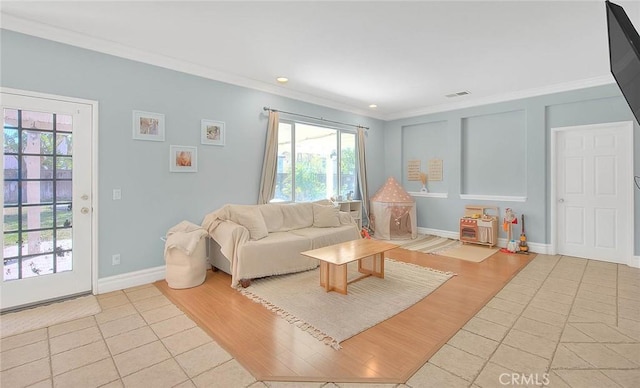 living room featuring light tile patterned flooring, baseboards, visible vents, and ornamental molding