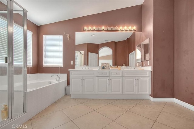 bathroom featuring a sink, lofted ceiling, a garden tub, and tile patterned floors