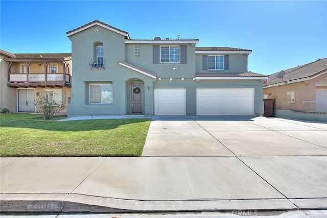 mediterranean / spanish house featuring a front yard, a tiled roof, driveway, and stucco siding