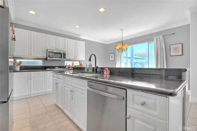 kitchen featuring a sink, ornamental molding, stainless steel appliances, white cabinets, and dark countertops