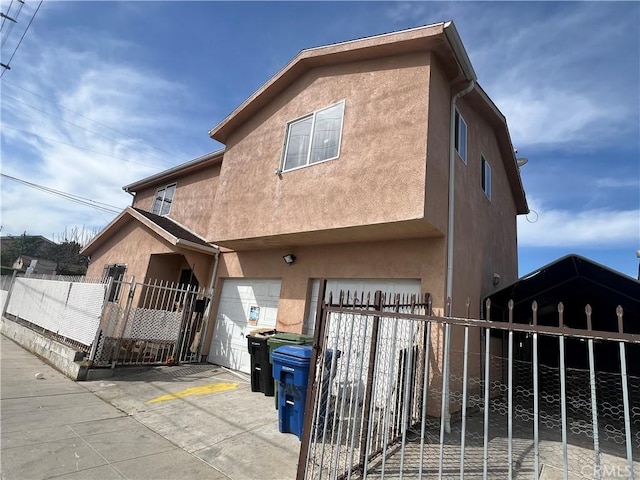 9145 Orchard Ave, Los Angeles, CA 90044 - view of front of property featuring stucco siding, a garage, and a gate