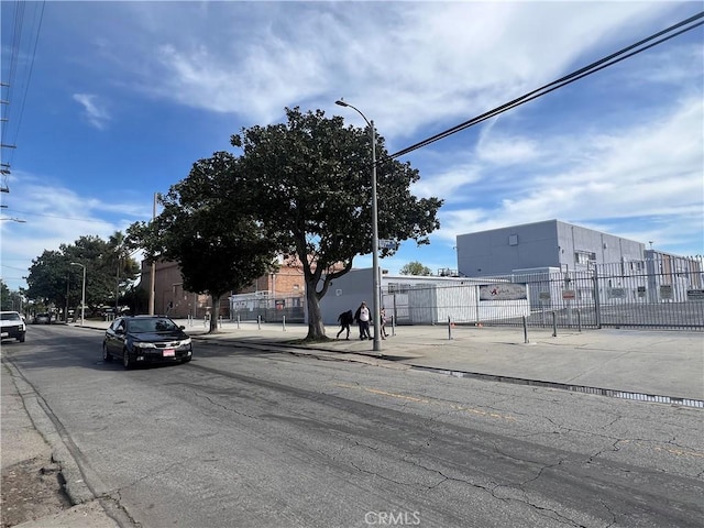 view of road with curbs, street lights, and sidewalks