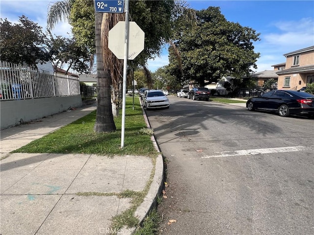 view of road featuring curbs, traffic signs, and sidewalks