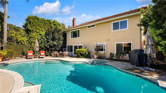 view of swimming pool with a patio, area for grilling, and a pool with connected hot tub