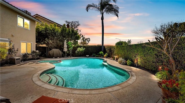 view of swimming pool with a patio, a fenced backyard, and a pool with connected hot tub