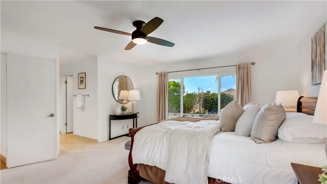 bedroom featuring light carpet and a ceiling fan