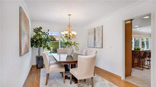 dining space featuring a notable chandelier, baseboards, light wood-style floors, and ornamental molding