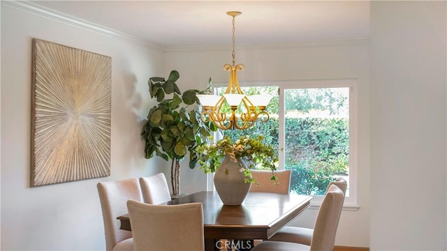 dining space with an inviting chandelier and ornamental molding