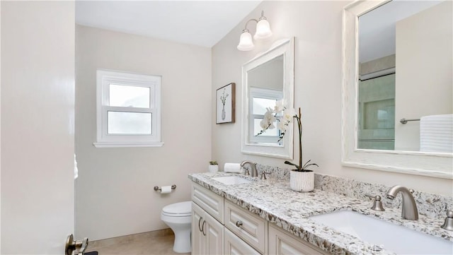 full bathroom featuring double vanity, toilet, and a sink