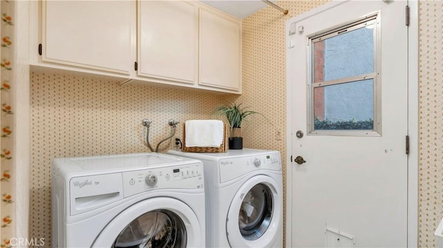 clothes washing area with cabinet space, washing machine and dryer, and wallpapered walls