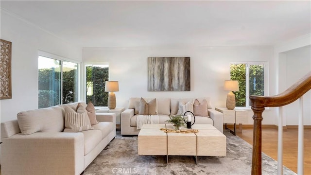 living area featuring baseboards, stairs, and light wood finished floors