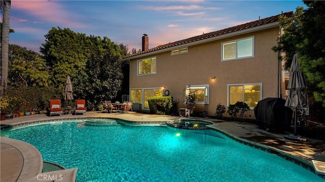 view of swimming pool featuring a patio and a pool with connected hot tub