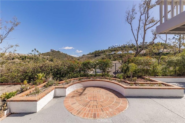 view of patio / terrace with fence and a mountain view