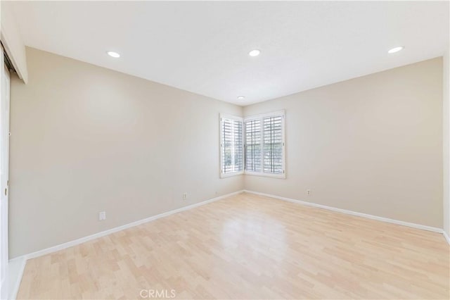 spare room with light wood-style flooring, recessed lighting, and baseboards